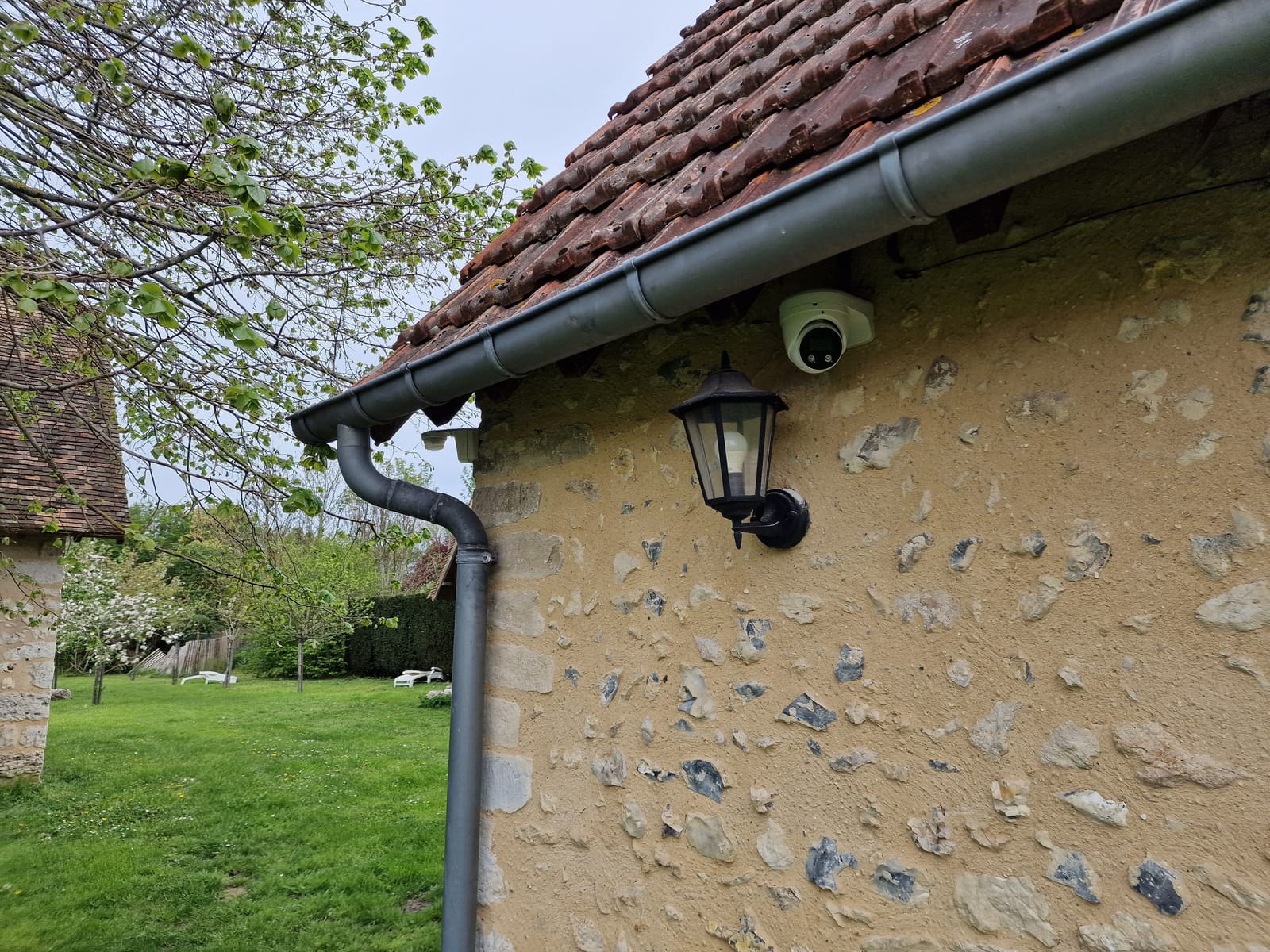 Caméra dôme posée sous la gouttière d'une longère en pierre dans l'Eure