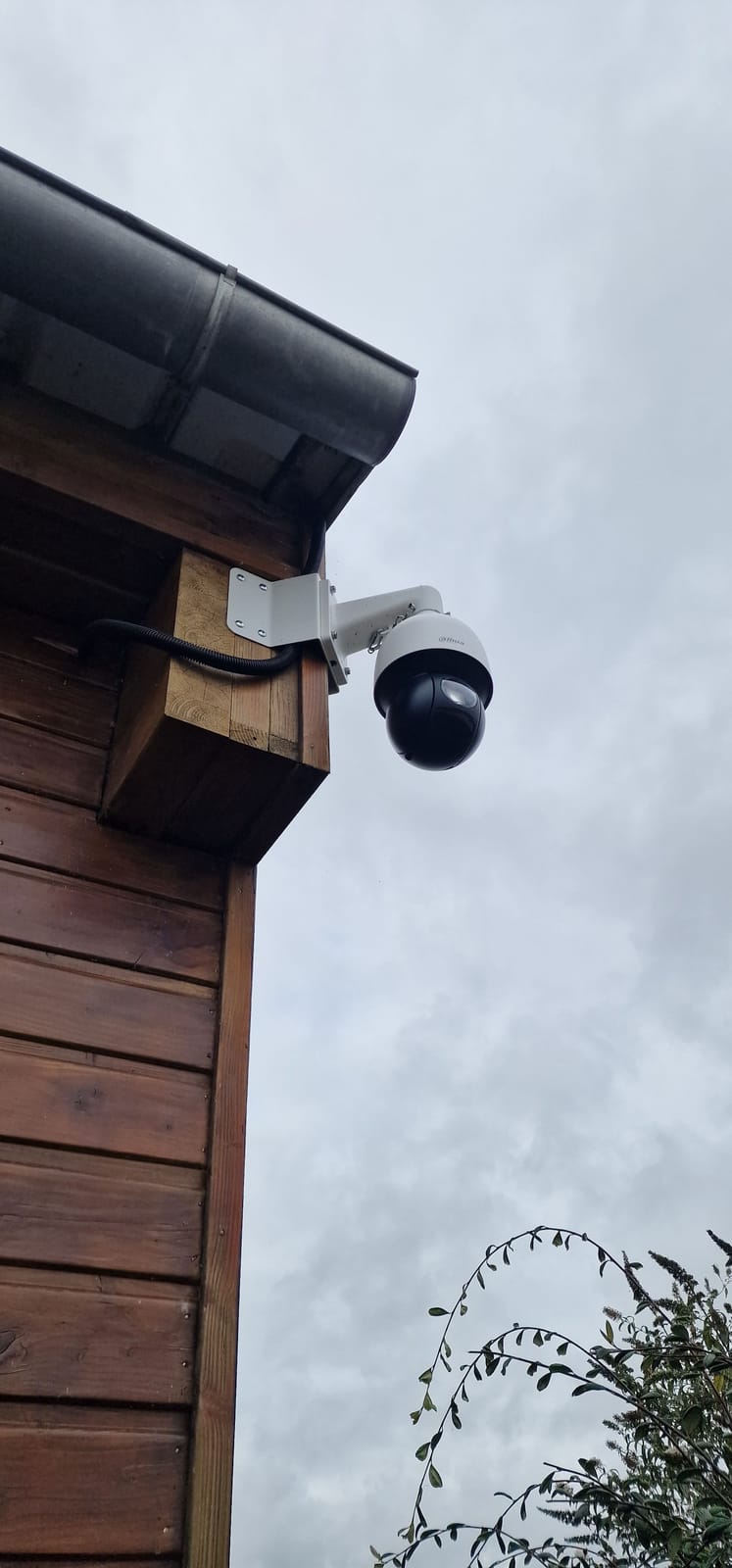 Caméra motorisée PTZ fixée à l'angle d'un chalet en bois