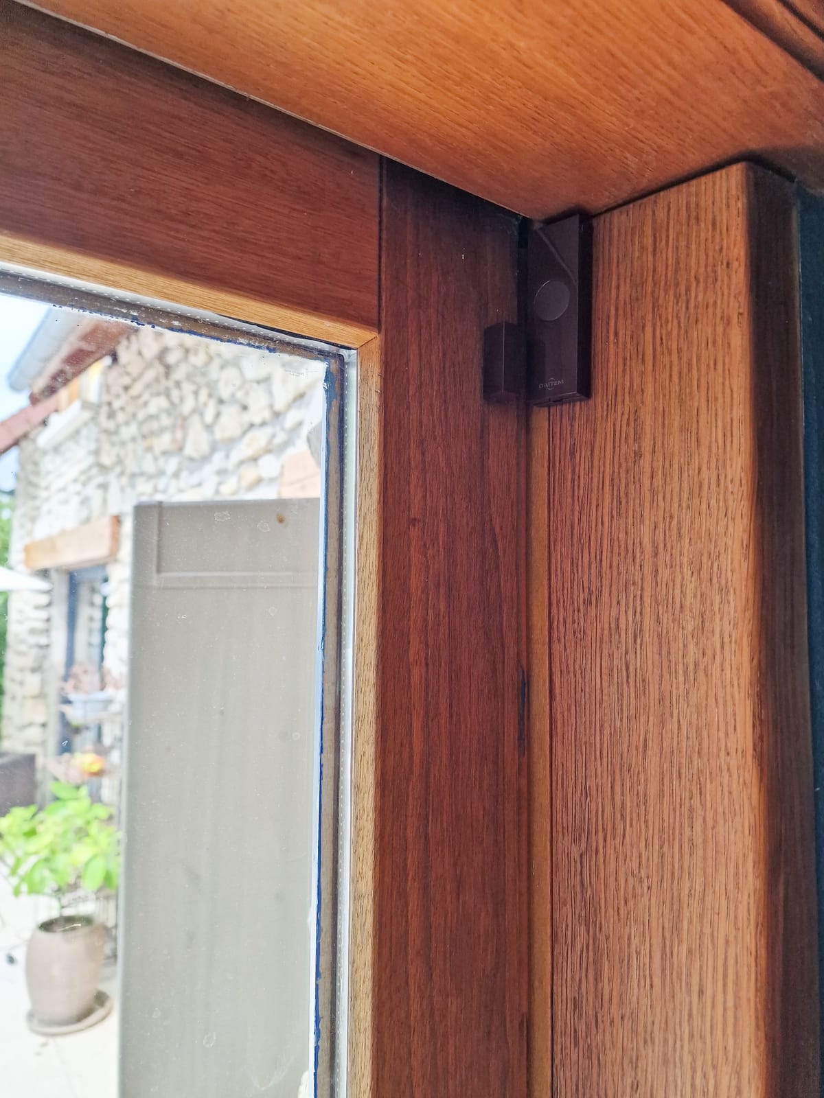 Détecteur d'ouverture posé sur une fenêtre en bois