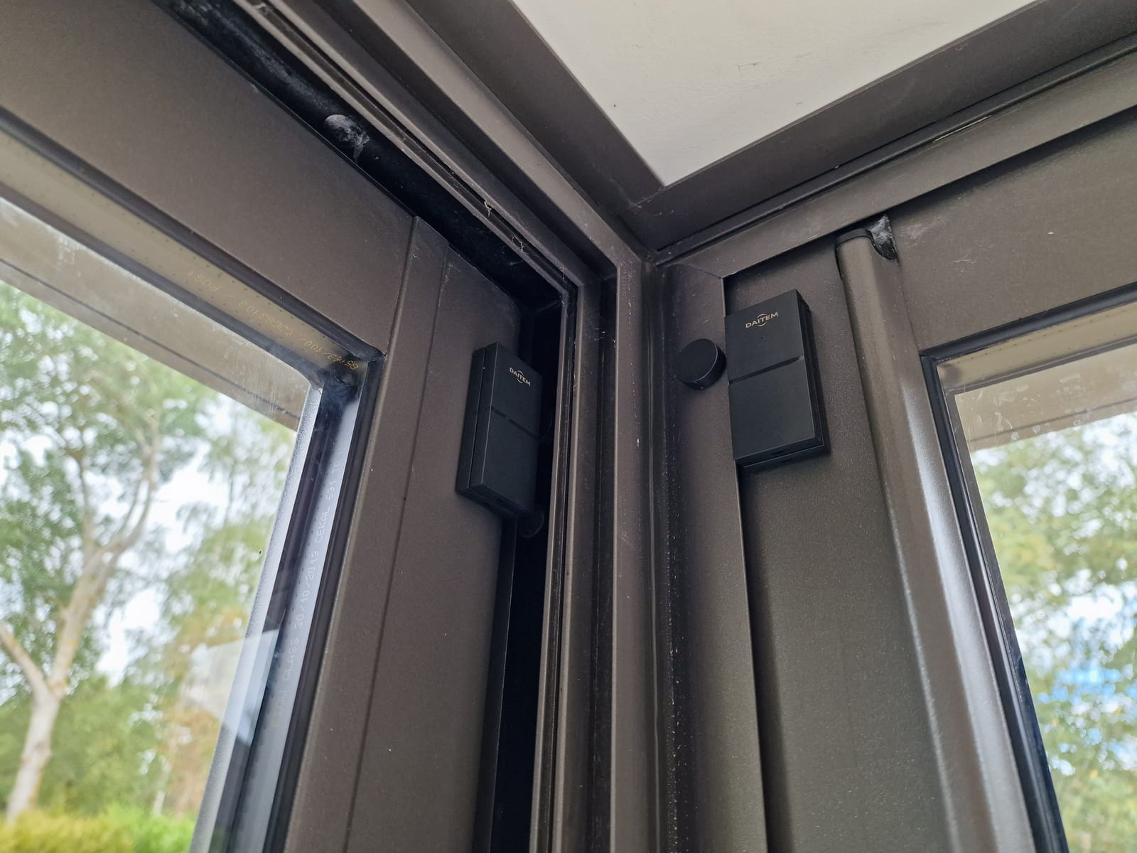 Détecteurs d'ouverture d'alarme posés sur une baie vitrée aluminium