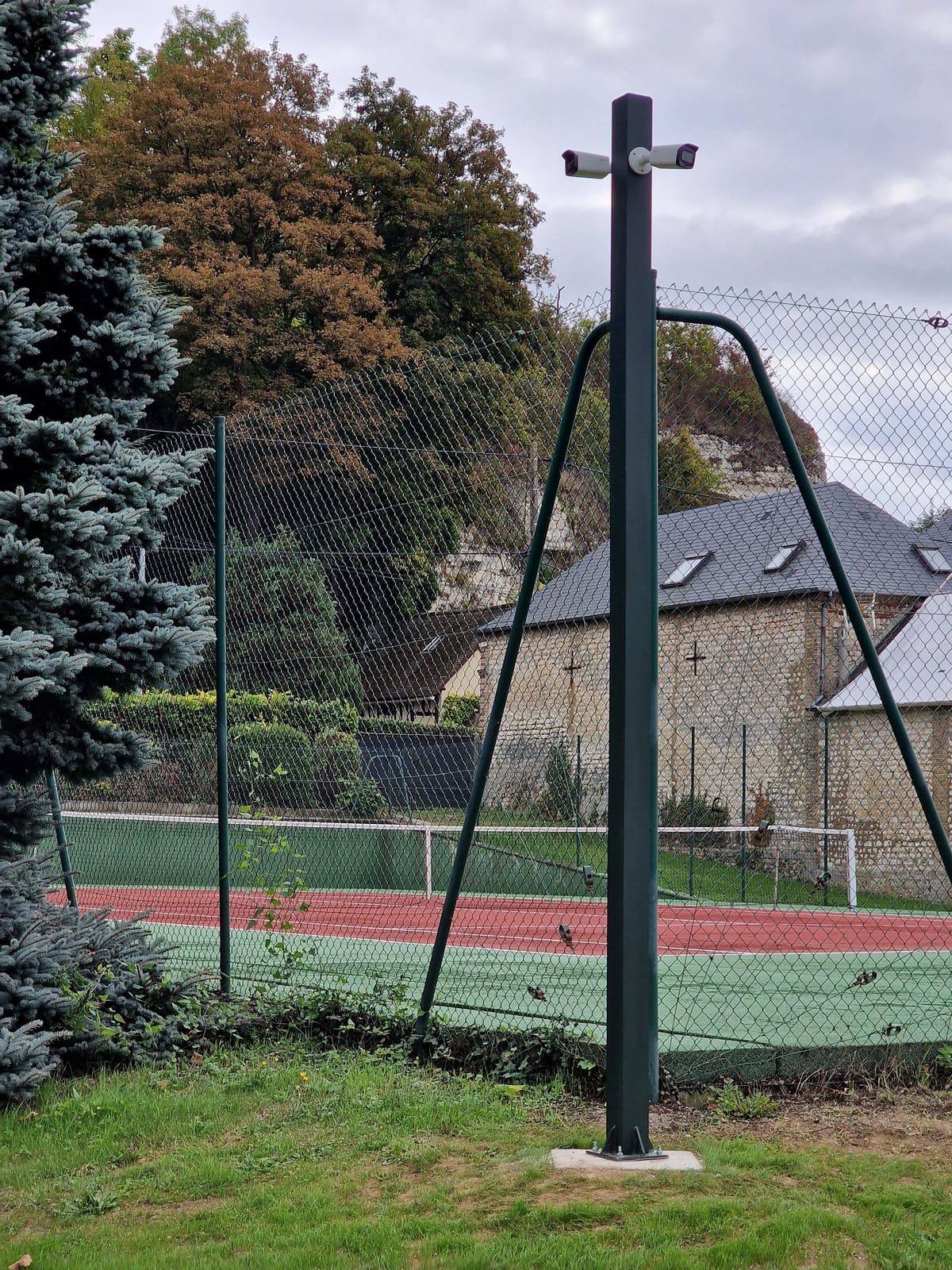 Mât équipé de deux caméras surveillant un terrain de tennis